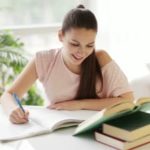 stock-footage-student-girl-studying-at-table-with-books-and-smiling