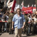 night-manager-the-2016-001-bbc-one-series-episode-1-tom-hiddleston-protesters-in-background