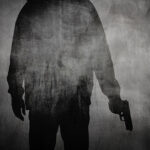 Silhouette or shadow of a man holding a gun