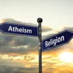 Arrow Road Signs Of Words Atheism And Religion On The Sunset Sky